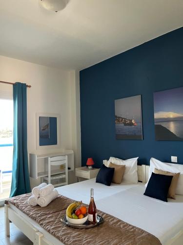 a bedroom with a large bed with a table with fruit on it at Maistrali Studios Skiathos in Koukounaries