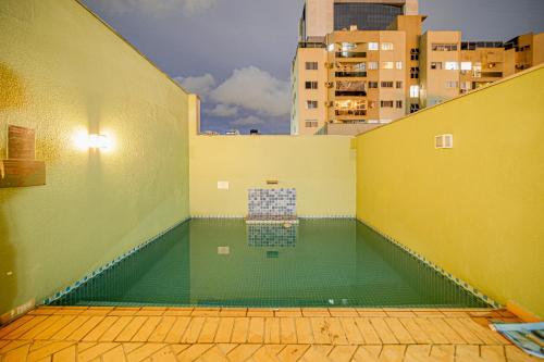 a swimming pool in the middle of a building at Cinema no Quarto: Smart TV 65", Piscina e Colado no Shopping! in Joinville