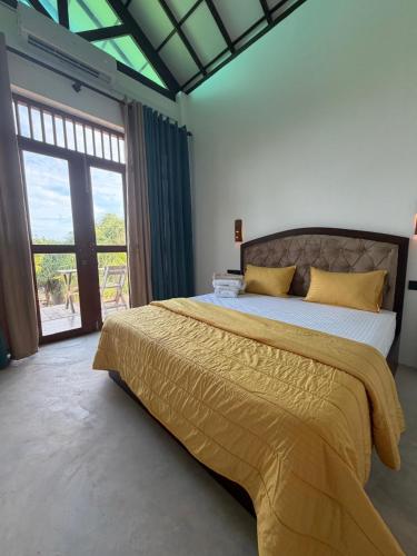 a bedroom with a large bed and a large window at Waves ranna cabana and seafood in Ranna