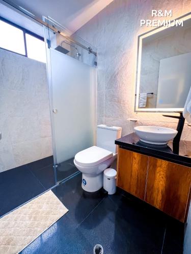 a bathroom with a toilet and a sink and a mirror at Estancia Exclusiva R&M in Pelileo