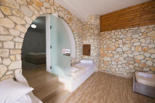 a room with a stone wall and a bedroom at Vila Dena in Vlorë