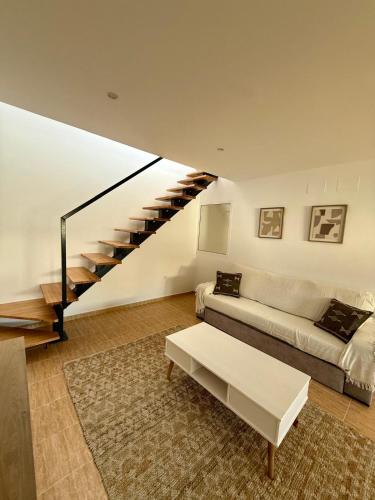 a living room with a couch and a staircase at Apartamentos La Janda in Benalup Casas Viejas