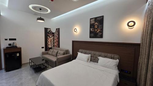a bedroom with a bed and a chair and a couch at Sky Grand Stays in Ulhāsnagar