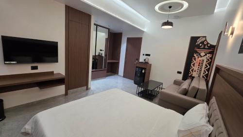 a hotel room with a bed and a television at Sky Grand Stays in Ulhāsnagar