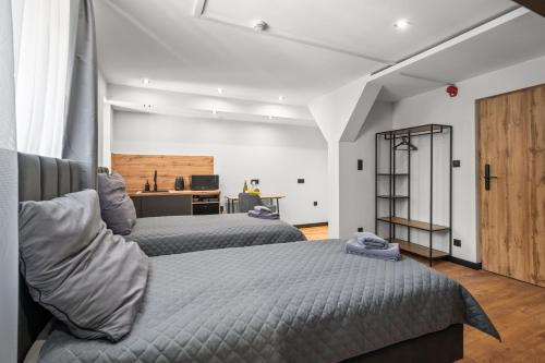 a bedroom with two beds and a desk at Central Platinum Apartments 10 in Rybnik