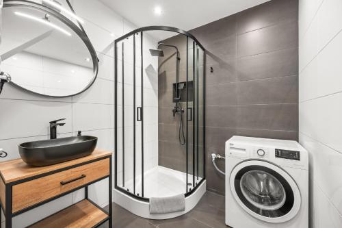 a bathroom with a sink and a washing machine at Central Platinum Apartments 10 in Rybnik