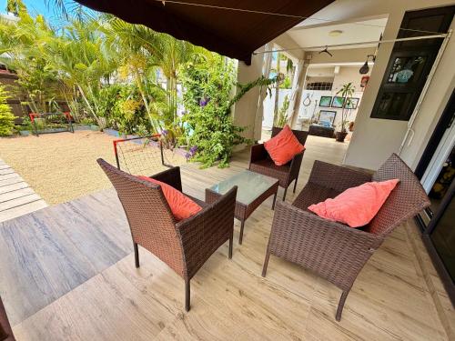 a patio with chairs and a table with orange pillows at Villa Luck in Trou aux Biches