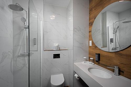 a white bathroom with a sink and a shower at Great National South Court Hotel in Limerick