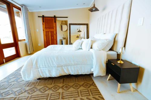 a bedroom with a large white bed and a mirror at Best for last resorts in Kalkheuvel