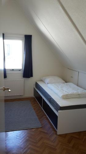 a bed in a room with a window and a bed sidx sidx sidx at Grevelingen 24 Ouddorp in Ouddorp