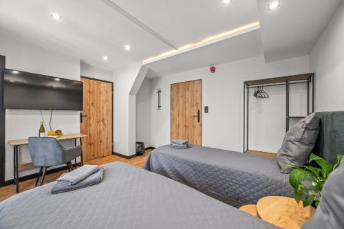 a bedroom with two beds and a table and a desk at Central Platinum Apartments 11 in Rybnik