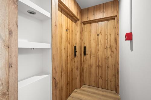 a wooden door in a bathroom with a bath tub at Central Platinum Apartments 11 in Rybnik
