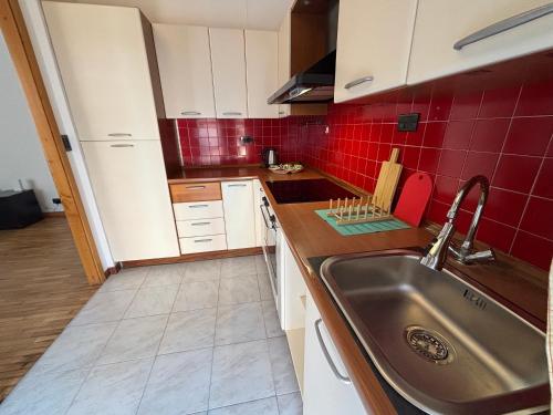 a kitchen with a sink and red tiles at Montegrappa smart stay Modena in Modena