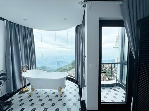 a bath tub in a bathroom with a large window at Lamay Villa Tam Đảo in Tam Ðảo