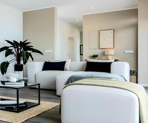 a living room with white furniture and a couch at Villa Serenity by Rentallido in Prazeres