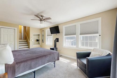 a bedroom with a bed and a chair and windows at East End Annex in Portland
