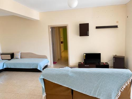 a living room with two beds and a tv at Treasure B&B - Garden Stay in Paloukia Salamina in Paloúkia