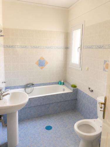 a bathroom with a tub and a sink and a toilet at Treasure B&B - Garden Stay in Paloukia Salamina in Paloúkia