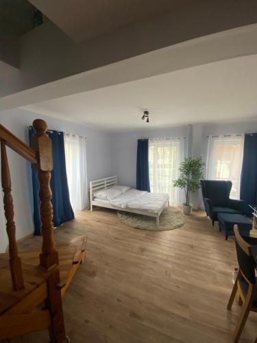 a living room with a bed and blue curtains at Apartament Kościuszki in Malbork