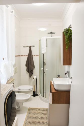 a bathroom with a sink and a toilet and a shower at 10 min from the lake, Spacious & Modern - Lalaland in Porto Ceresio
