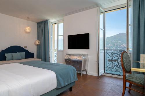 a hotel room with a bed and a large window at Grand Hotel Menaggio in Menaggio