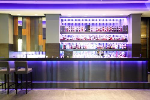 a bar in a restaurant with purple lighting at Hotel Reykjavík Grand in Reykjavík