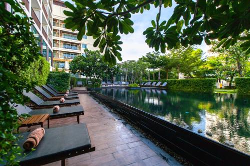 a row of benches sitting next to a river at Fifth Pattaya Jomtien By Shiwalai Int in Jomtien Beach