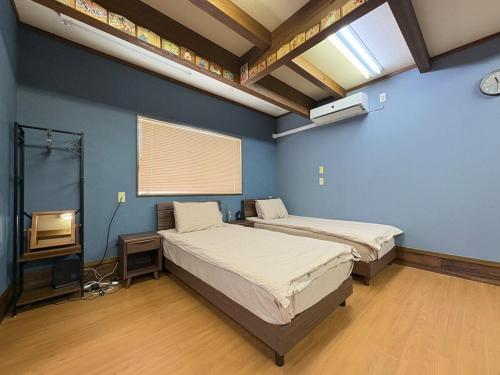 a room with two beds and a television in it at Dons House in Fukuoka