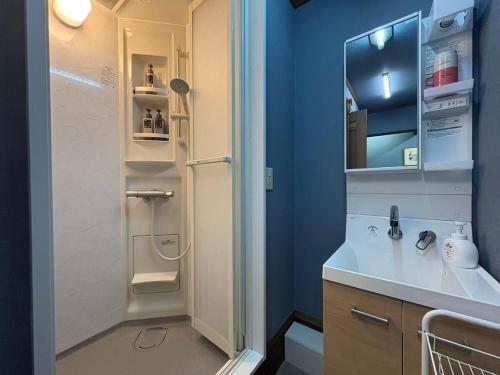 a bathroom with a sink and a shower with a refrigerator at Dons House in Fukuoka