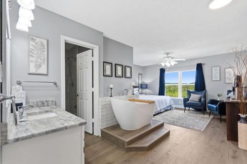 a bathroom with a tub and a bedroom with a bed at WP252 Be Our Guest in Pigeon Forge