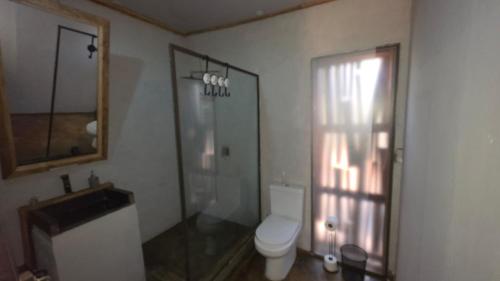 a bathroom with a toilet and a shower and a window at Vulture's View 6 in Hartbeespoort