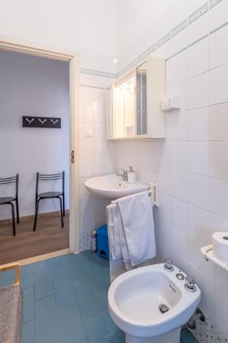 a white bathroom with a sink and a toilet at Due passi dal mare - Residence Sirena in Punta Marina
