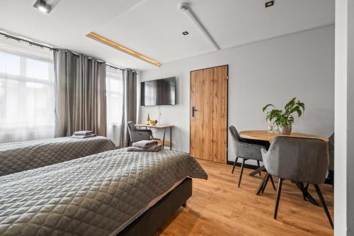 a bedroom with two beds and a desk and a table at Central Platinum Apartments 12 in Rybnik