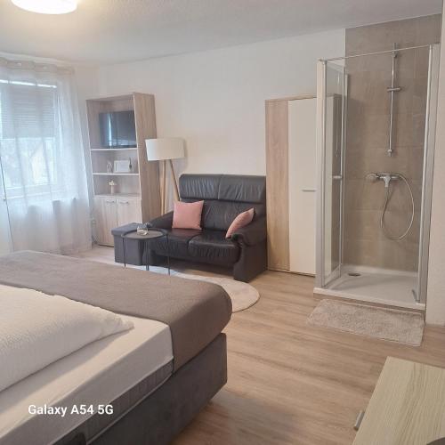 a living room with a bed and a couch at Gasthaus Sonne 2 in Braunsbach
