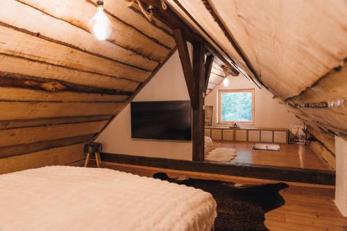 a room with a bed and a tv in a house at The Nook - Sauna, Pool, Ice Bath in Celje