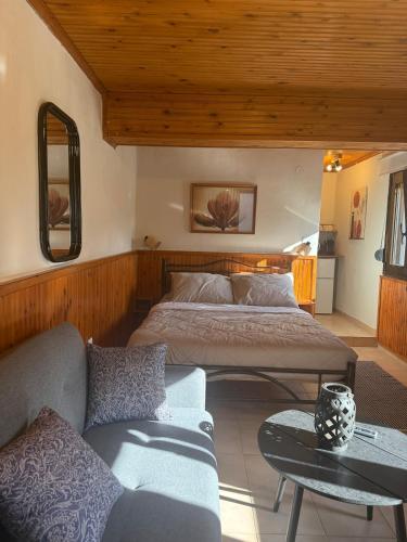 a bedroom with two beds and a couch in it at The Village Studio AVLI Upper Vrasna in Nea Vrasna