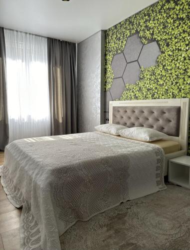 a bedroom with a large bed with a green wall at Квартира,Еврейская,1 in Bilhorod-Dnistrovskyi