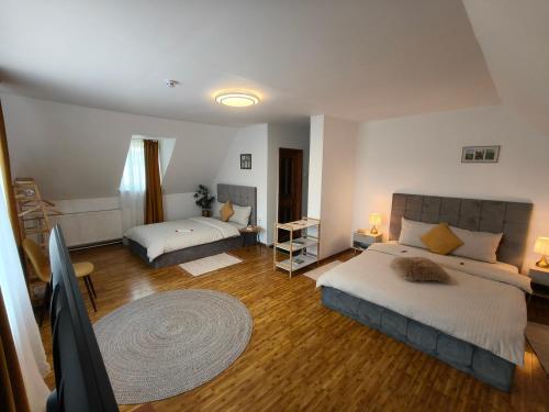 a bedroom with two beds and a rug at Baroc Boutique Hotel in Topliţa