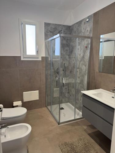 a bathroom with a shower and a toilet and a sink at THE PORT Guest Rooms in San Ferdinando