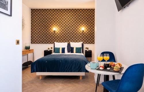a bedroom with a bed and a table with two chairs at Hôtel Mijo's in Fontenay-sous-Bois