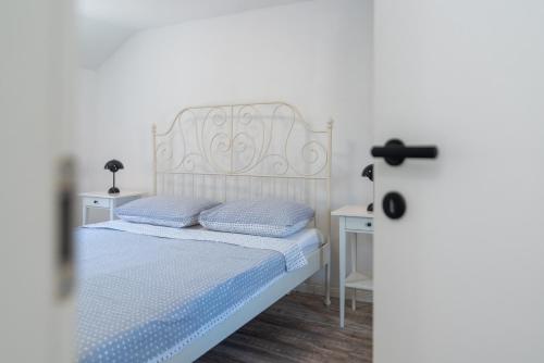 a white bed with two pillows next to a door at Balatura House in Trogir