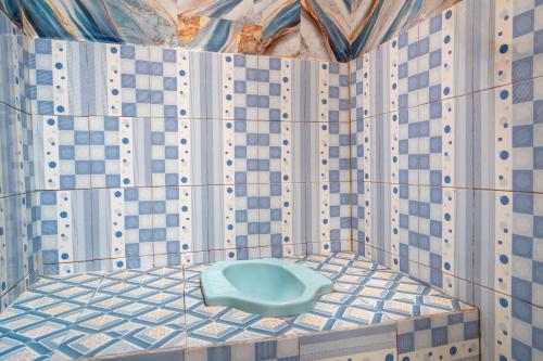 a bathroom with a blue toilet in a tiled floor at TB Villa Resort By ARBA in Palayangan