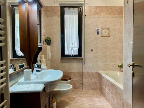 a bathroom with a sink and a toilet and a tub at Nuvola House in Mandello del Lario