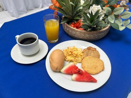 a table with a plate of breakfast food and a cup of coffee at Park Hotel in Santa Marta