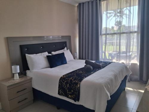 a bedroom with a large bed and a window at Ocean Breeze 12 Boulder Bay in Ballito