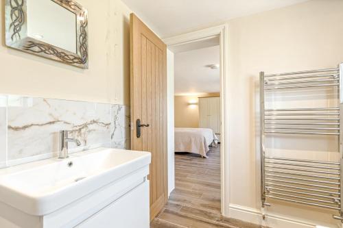 a bathroom with a sink and a mirror at Chestnut Cottage in Bix