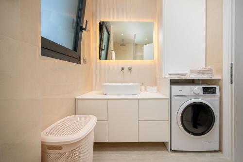a bathroom with a washing machine and a sink at Besa Luxury Villas in Kos
