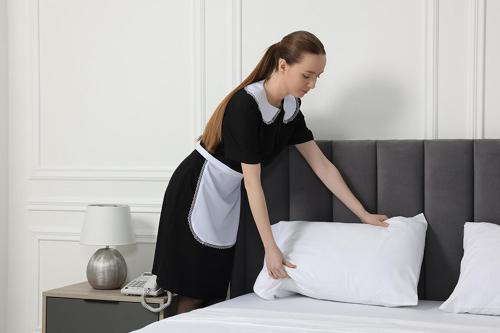 a woman is putting a pillow on a bed at Egypt Pyramids Hotel in Cairo
