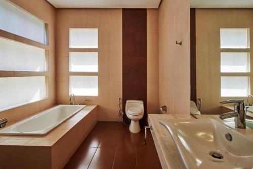 a bathroom with a tub and a toilet and a sink at Breeze Blows City View Villa 4 Bedrooms and 1 Familly Bedroom With a Private Heated Swimming Pool and a Billiard Table in Bandung
