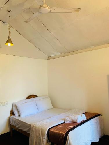 a bed in a room with a ceiling at saha surf camp in Arugam Bay
